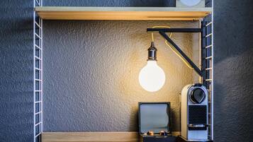 A shelf with a lamp, a speaker, and a small box.