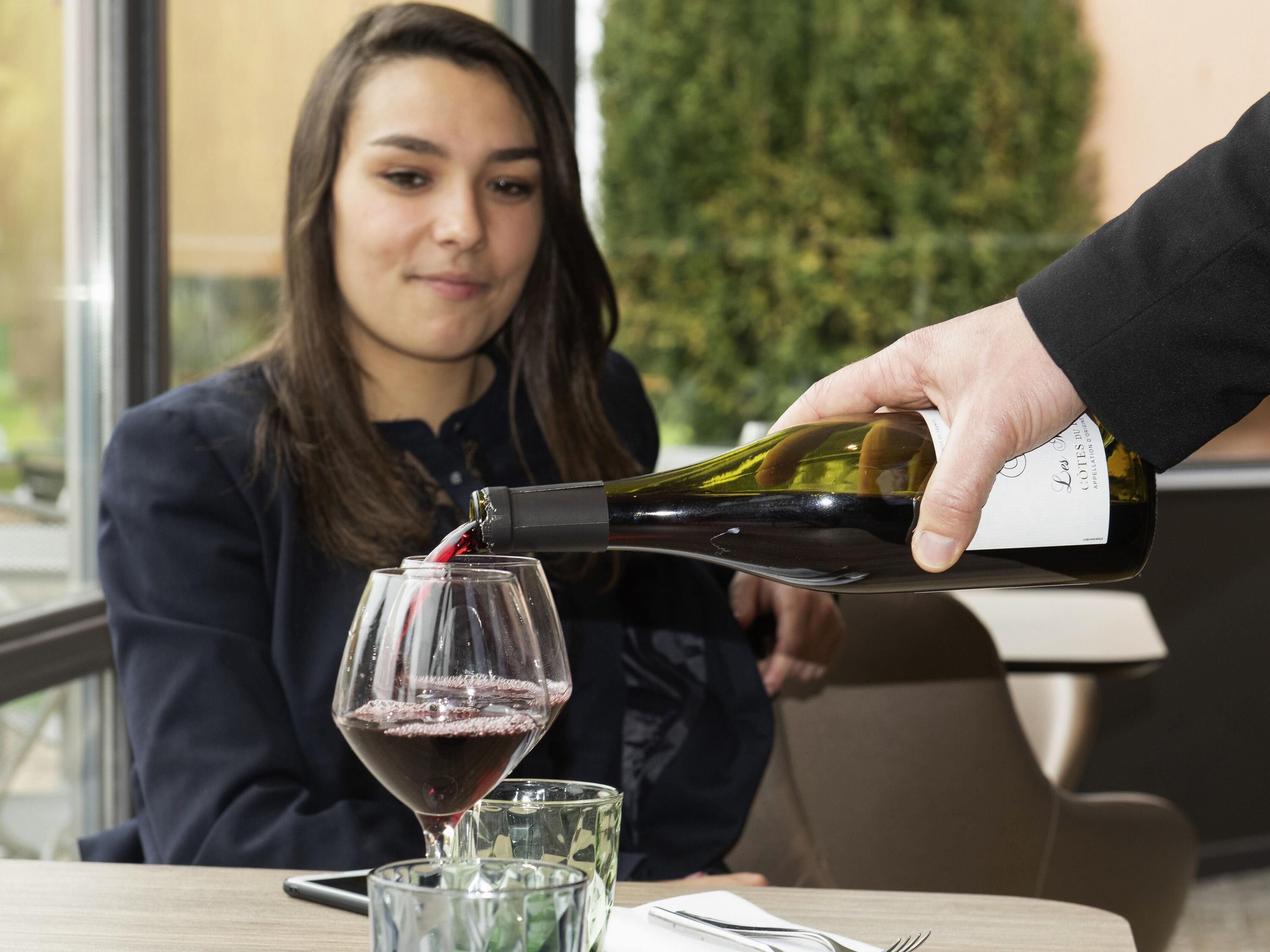 Una persona sirviendo vino en una copa.