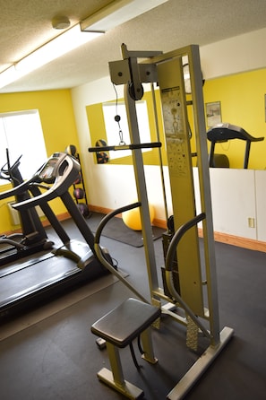 A gym with exercise equipment including a treadmill, weight machine, and stepper. - Days Inn by Wyndham Grand Island (Grand Island)