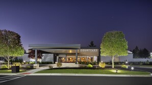 A Courtyard by Marriott hotel at night with a covered entrance, well-lit exterior, and landscaped surroundings. - Courtyard by Marriott Southfield (Southfield)