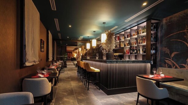 A restaurant with a long counter, bar area, and seating. - Universo And Nord Hotel (Venice)