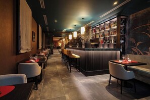 A restaurant with a long counter, bar area, and seating. - Universo And Nord Hotel (Venice)