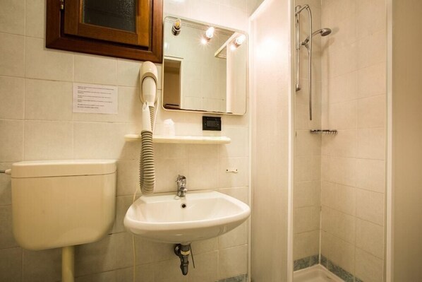 Un baño con inodoro, lavamanos y ducha.