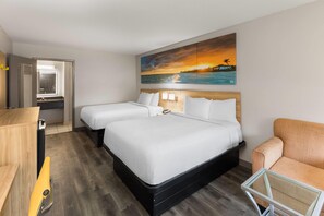 A hotel room with two beds, a desk, a chair, and a painting of a sunset over the ocean. - Days Inn by Wyndham Natchitoches (Natchitoches)