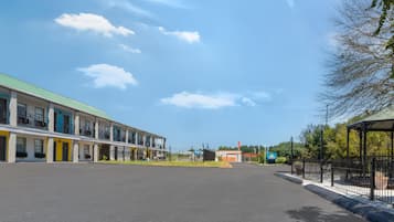 Ein Hotel mit Gründach, einem Days Inn Schild und einem eingezäunten Parkplatz.