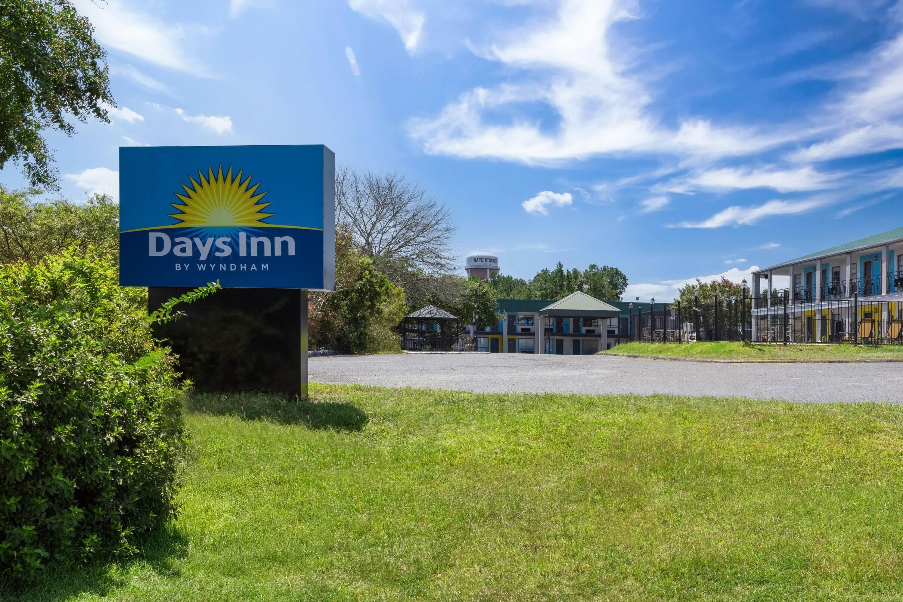 A Days Inn sign with a clear sky and a parking lot in the foreground.