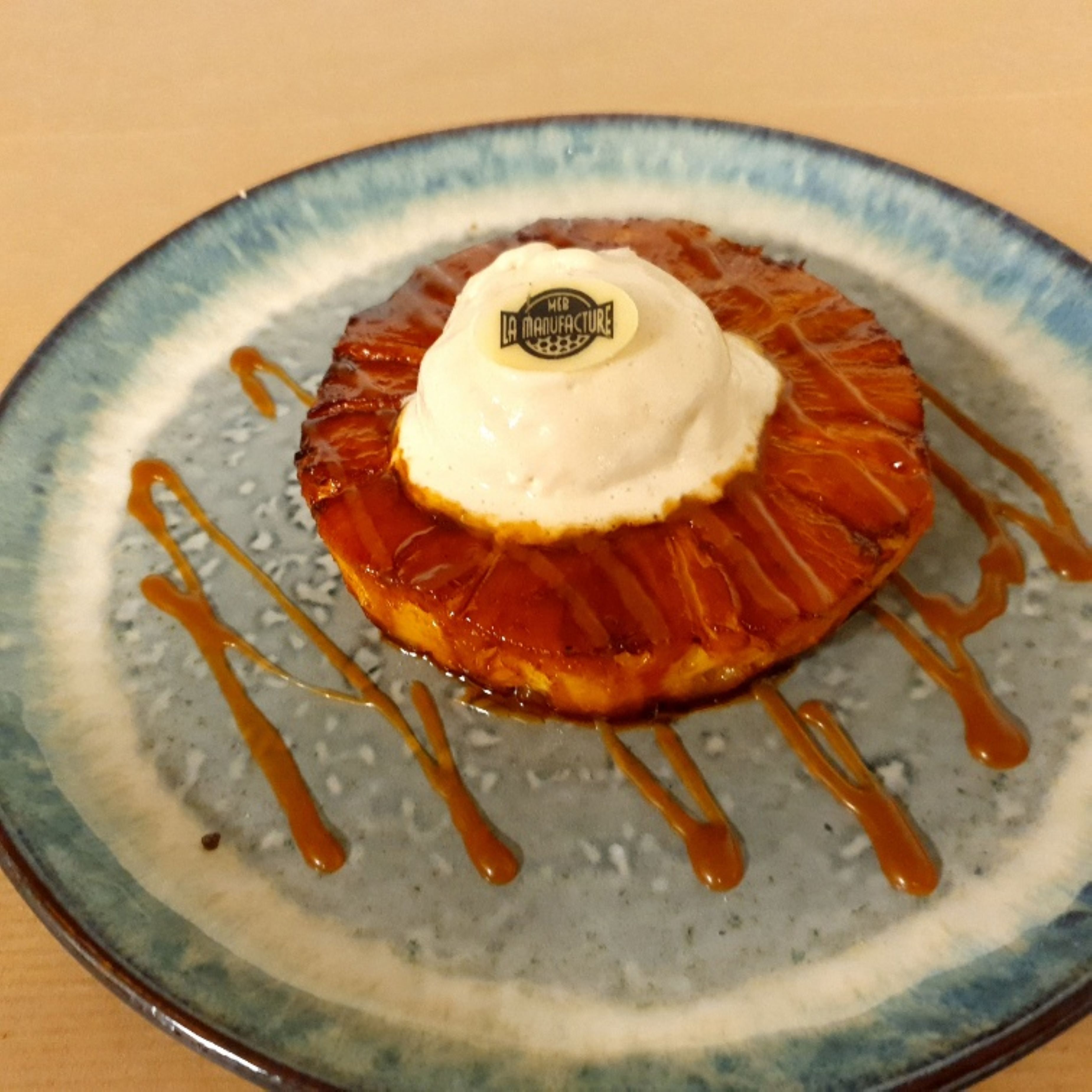 Un dessert servi dans une assiette, nappé d’un filet de caramel.