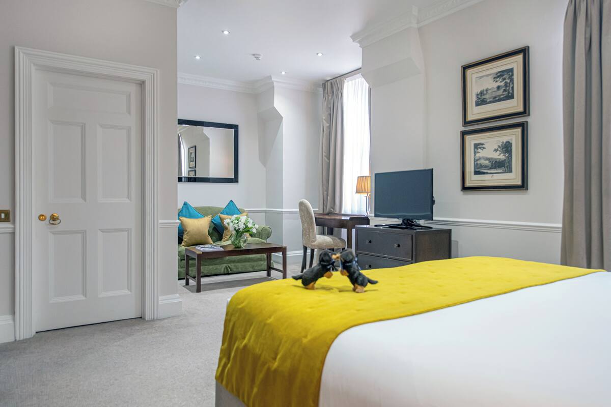 Une chambre d’hôtel avec un grand lit, un bureau avec un ordinateur, une chaise et un téléviseur.