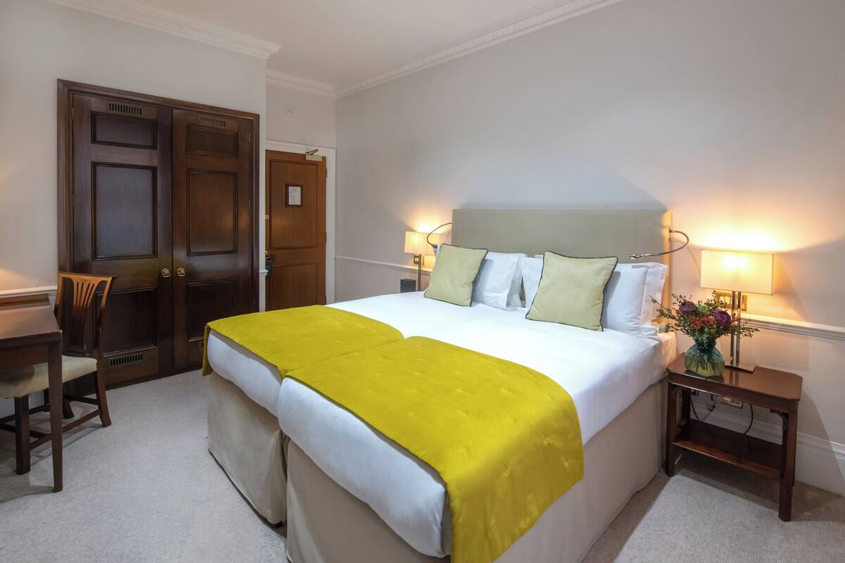 Une chambre d’hôtel avec un grand lit, un bureau et une chaise.