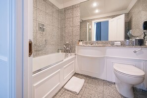 A modern bathroom with a freestanding bathtub, a vanity with a mirror, and a toilet. - Dukes London (London)