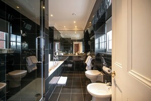 A modern bathroom with a glass-enclosed shower, a large mirror, and a vanity with a sink and mirror. - Dukes London (London)