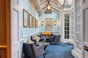 A room with a blue carpet, a sofa set, and framed pictures on the wall. - Dukes London (London)