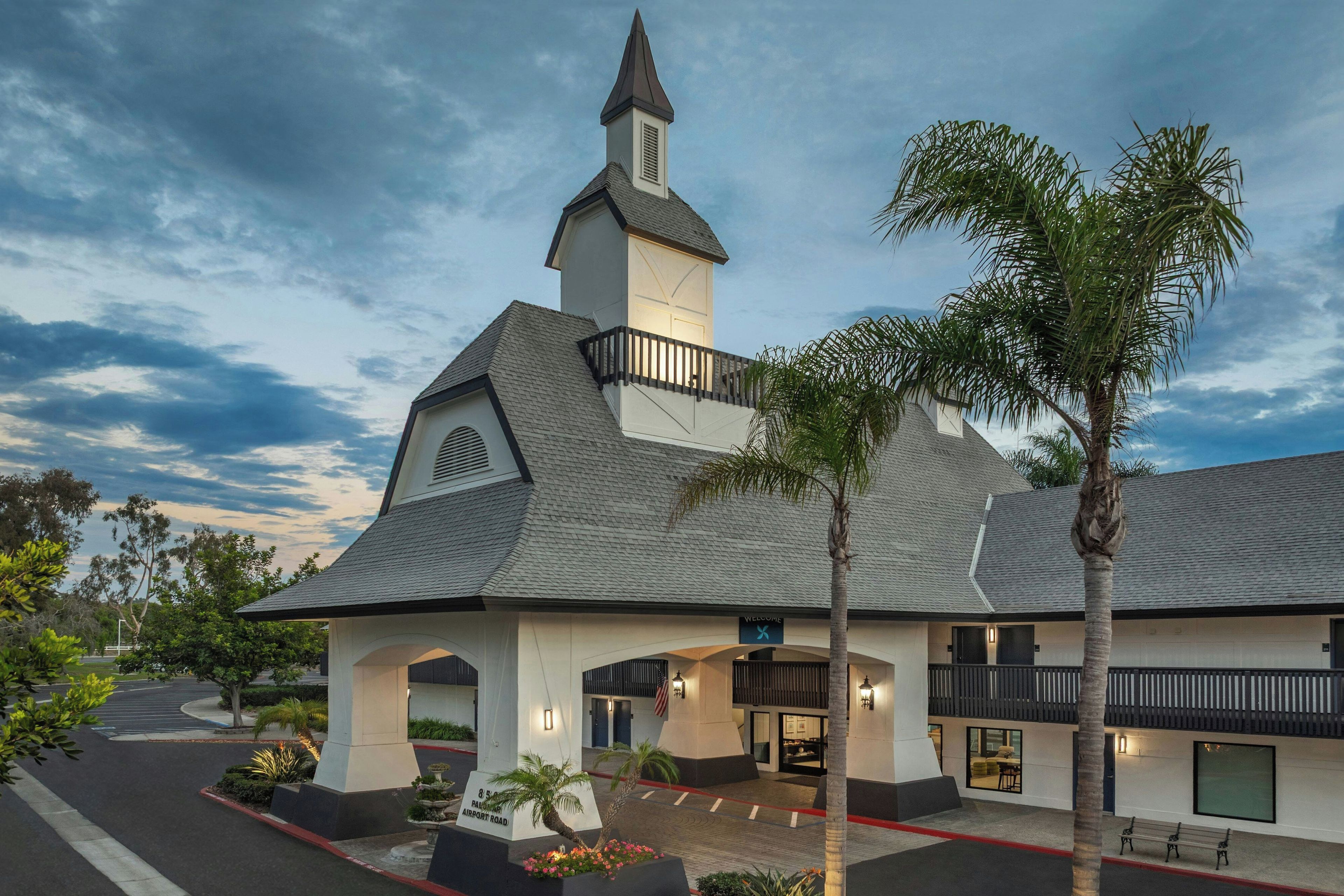 A hotel with a prominent steeple, a welcoming entrance, and a landscaped driveway.