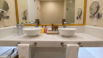 Un baño de hotel con dos lavamanos, un espejo grande y un perchero para toallas.