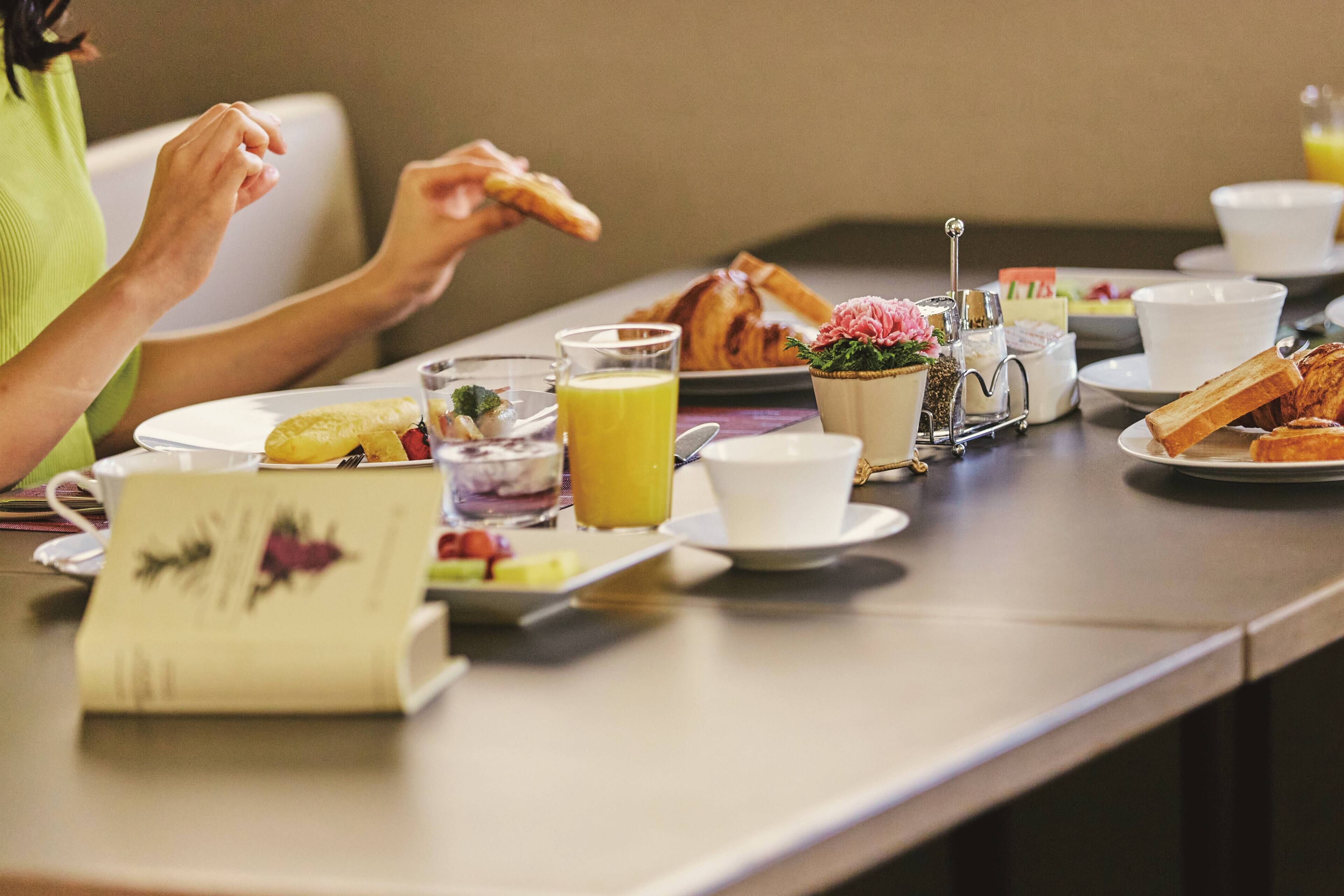 A breakfast setting with various food items and drinks on a table.