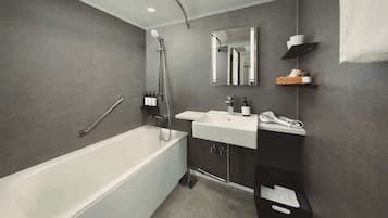 A modern bathroom with a bathtub, a sink, and a mirror.