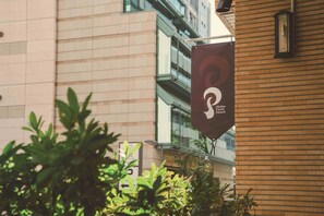 A sign for Shiba Park Hotel with a modern building in the background. - Shiba Park Hotel (Tokyo)