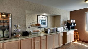 A breakfast bar with a refrigerator, toaster, and coffee station. - Angel Inn Central (Branson)