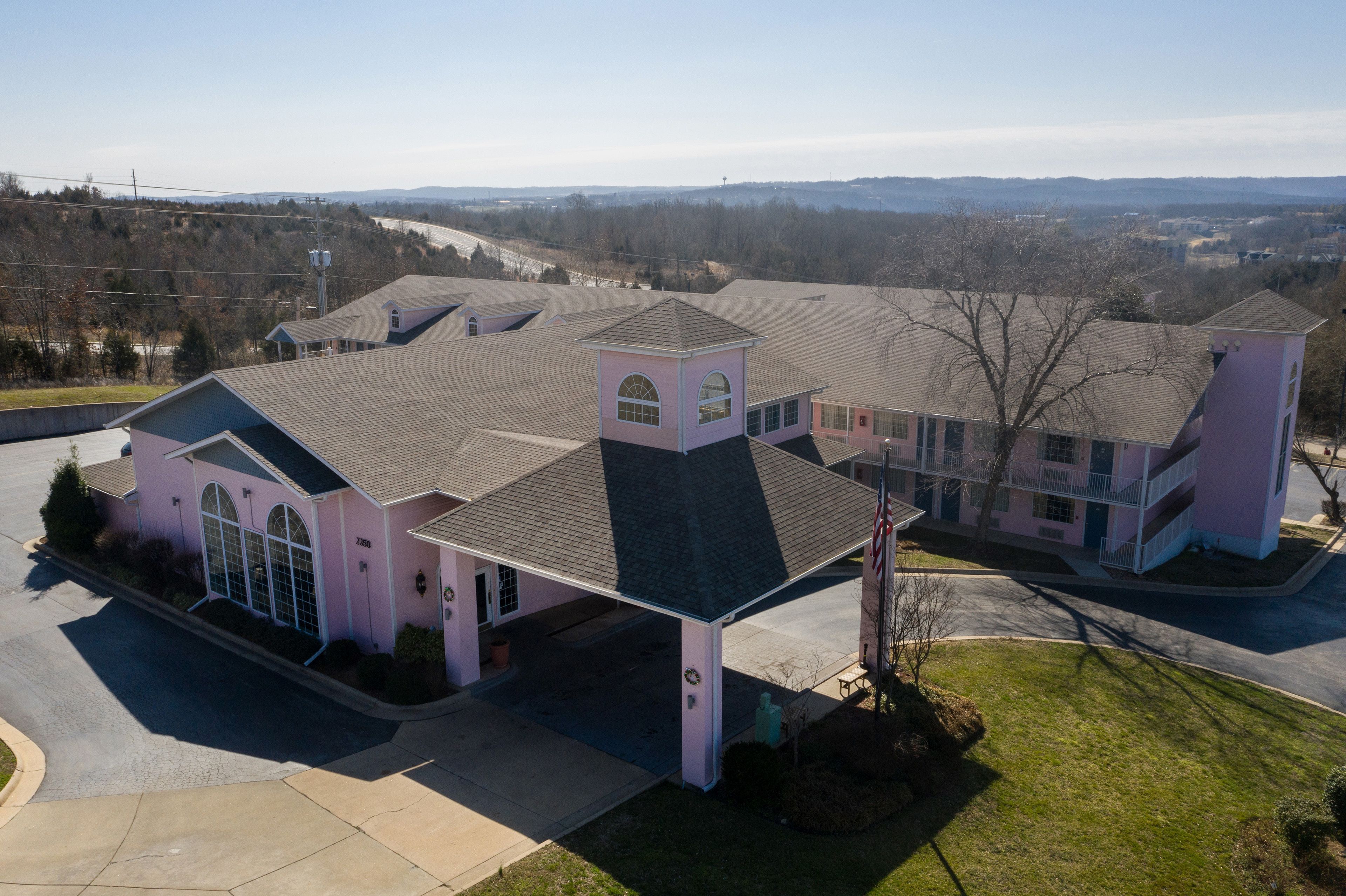 A large, multi-story house with a central tower, multiple entry points, and a driveway.