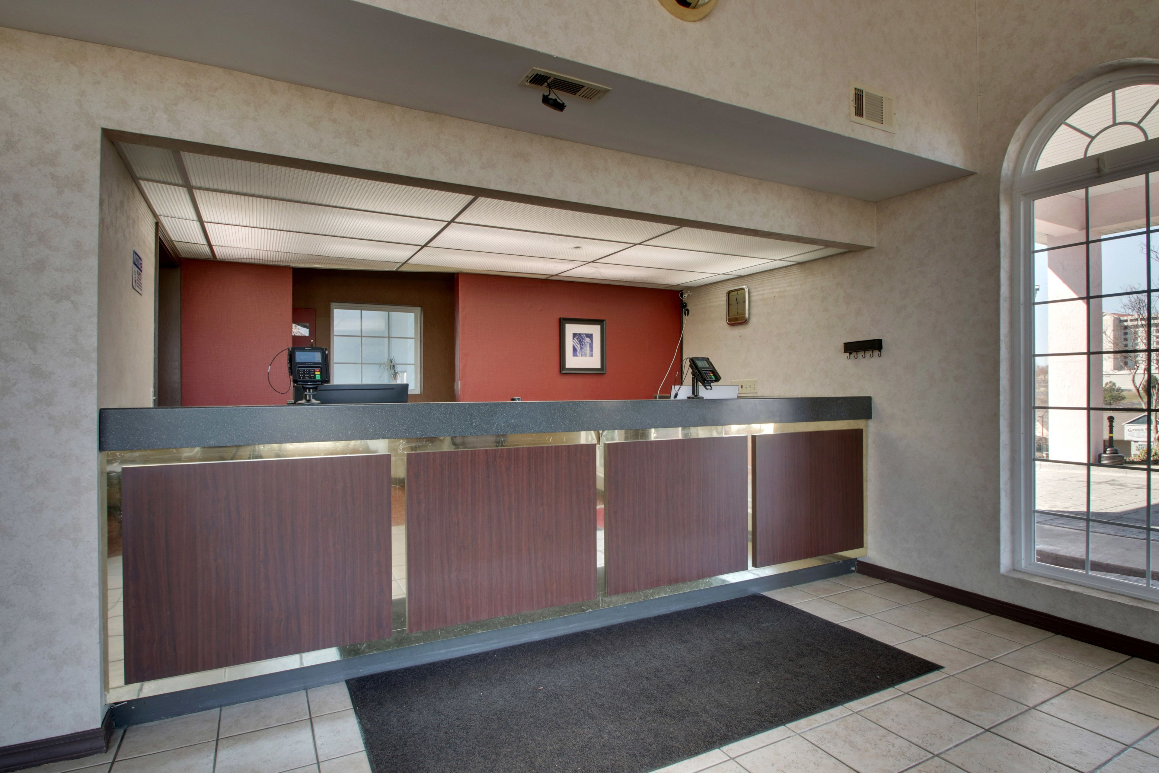 A reception area with a counter, a telephone, and a framed picture on the wall.