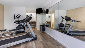 A gym with treadmills, a stationary bike, and a mirror wall.