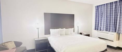 Une chambre d’hôtel avec un grand lit, des tables de chevet, un bureau et une chaise.