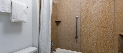 A bathroom with a bathtub, shower, and toilet.