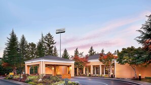 A hotel with a 'Bona Select' sign, a covered outdoor seating area, and a landscaped entrance. - Sonesta Select Seattle Bellevue Redmond (Bellevue)