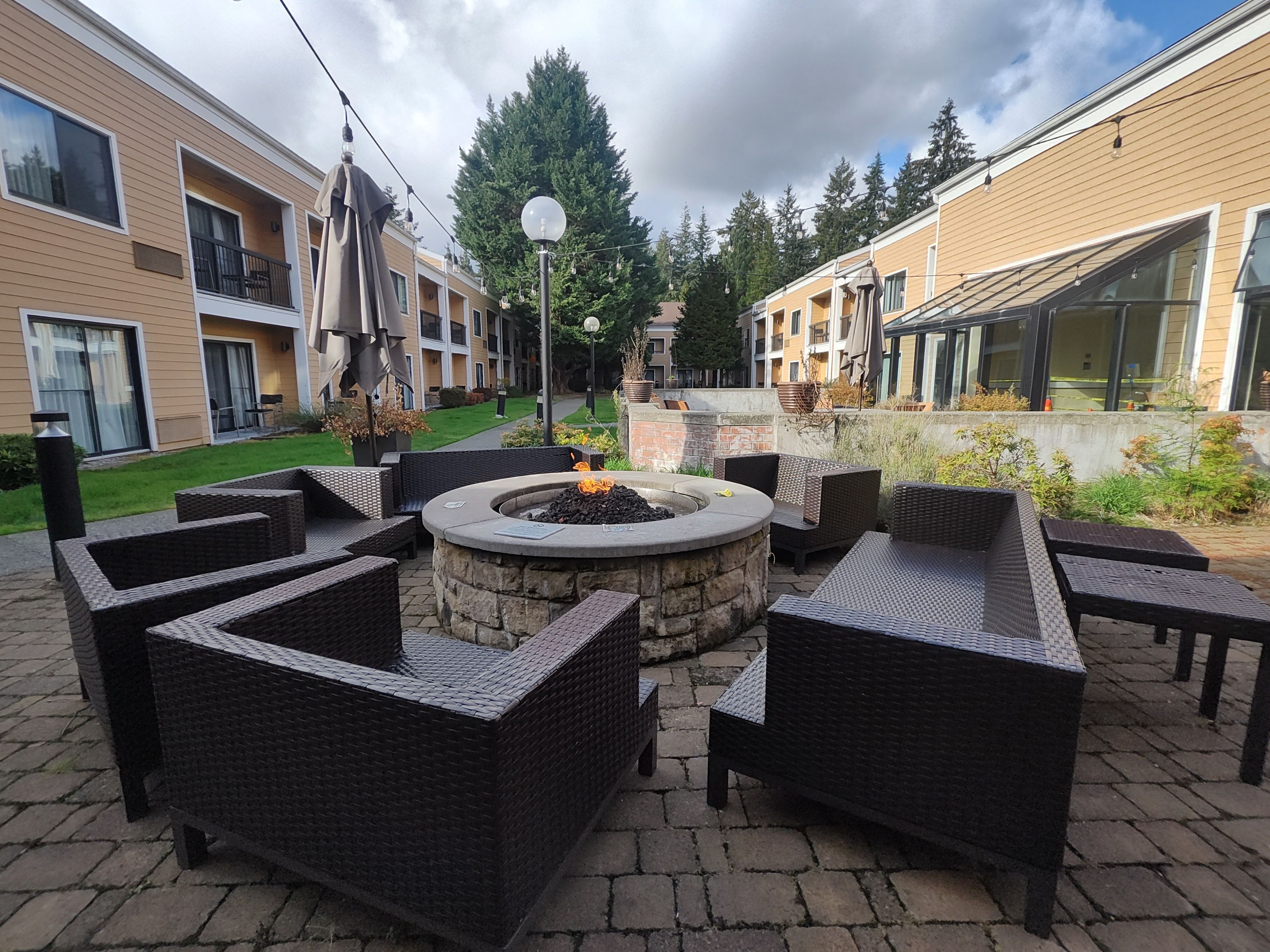 A courtyard with outdoor seating, a fire pit, and a view of residential buildings.