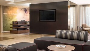 A modern living room with a sectional sofa, a round coffee table, and a built-in shelving unit. - Sonesta Select Seattle Bellevue Redmond (Bellevue)