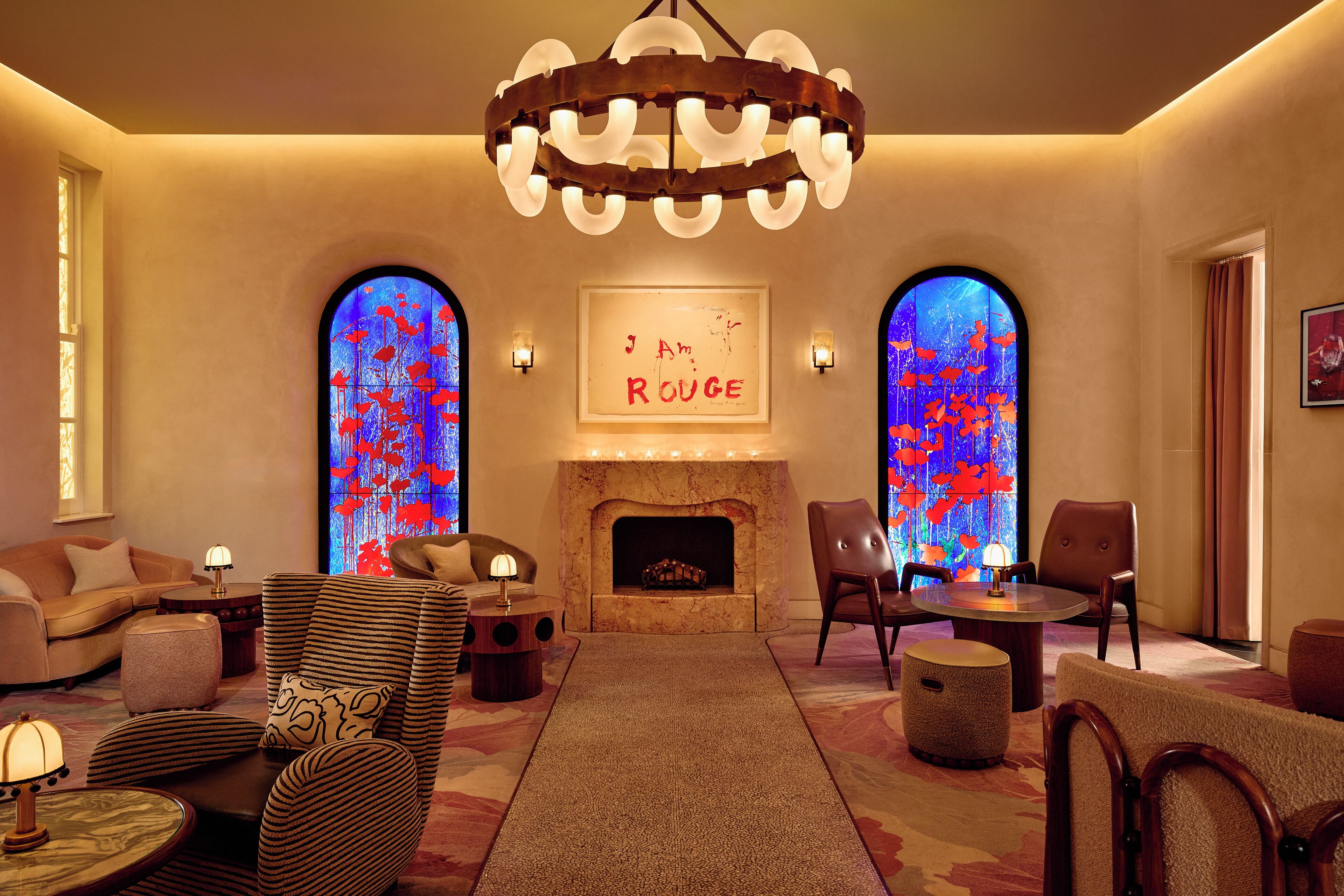 A cozy lounge area with a fireplace, comfortable seating, and a chandelier.