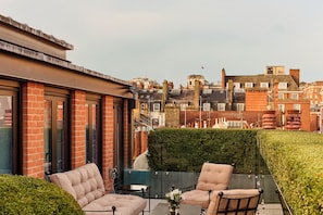 A rooftop terrace with seating and a view of surrounding buildings. - The Connaught, Maybourne  (London)
