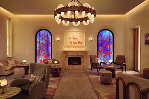 A cozy lounge area with a fireplace, comfortable seating, and a chandelier.