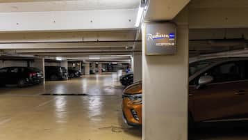 A Radisson Blu hotel reception area with multiple parked cars and a wet floor.