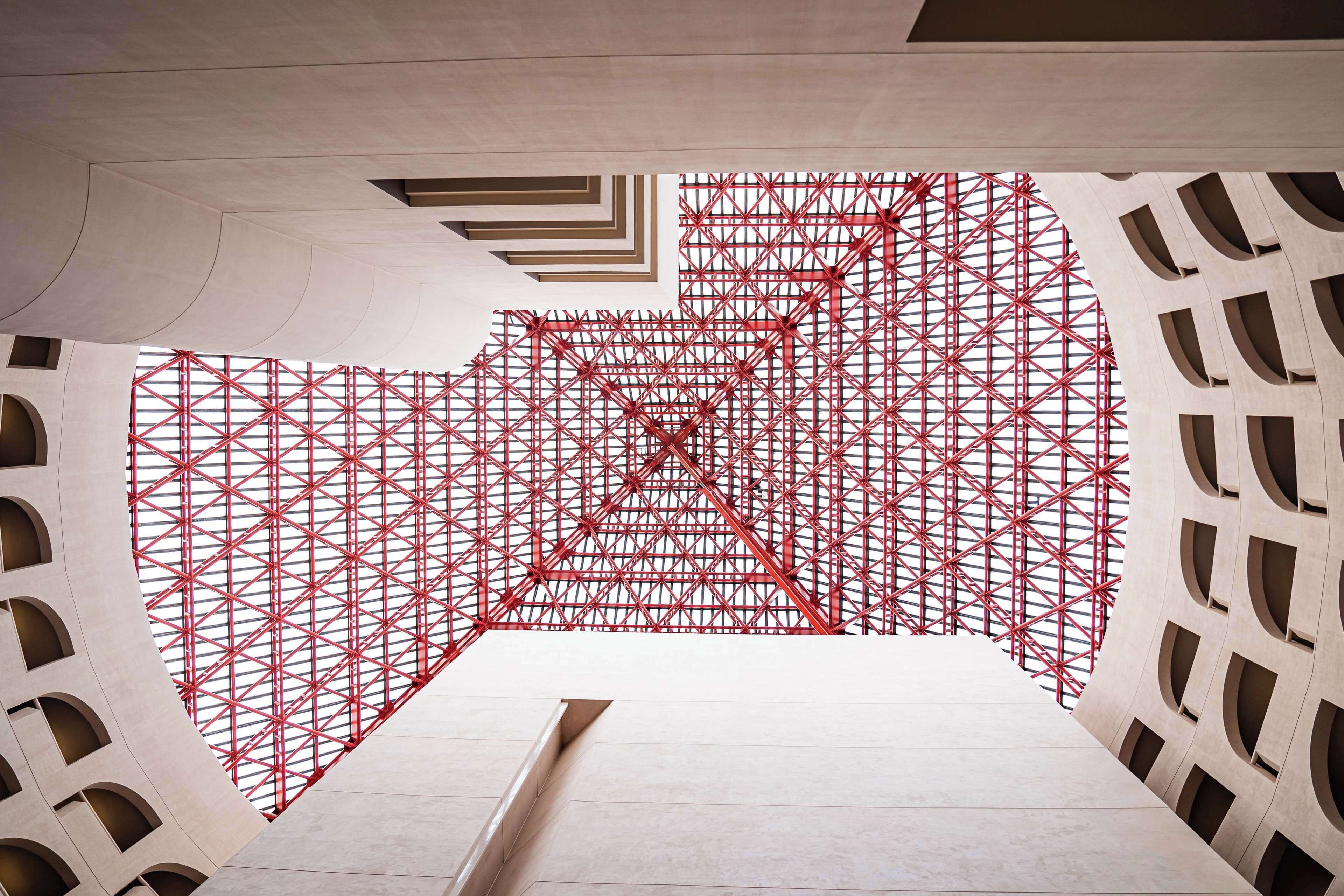 Una estructura arquitectónica moderna con patrones geométricos y un llamativo diseño de cuadrícula roja.