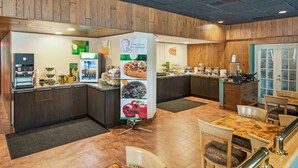 A breakfast area with a coffee machine, a fruit display, and a seating area with tables and chairs. - Quality Inn & Suites Virginia MN (Virginia)