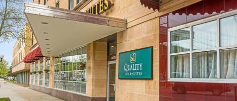 A hotel entrance with a sign for 'Quality Inn & Suites' and a covered walkway.