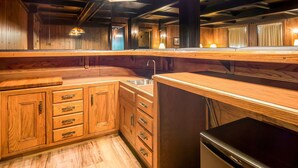 A wooden kitchen with a sink, cabinets, and a refrigerator. - Quality Inn & Suites Virginia MN (Virginia)