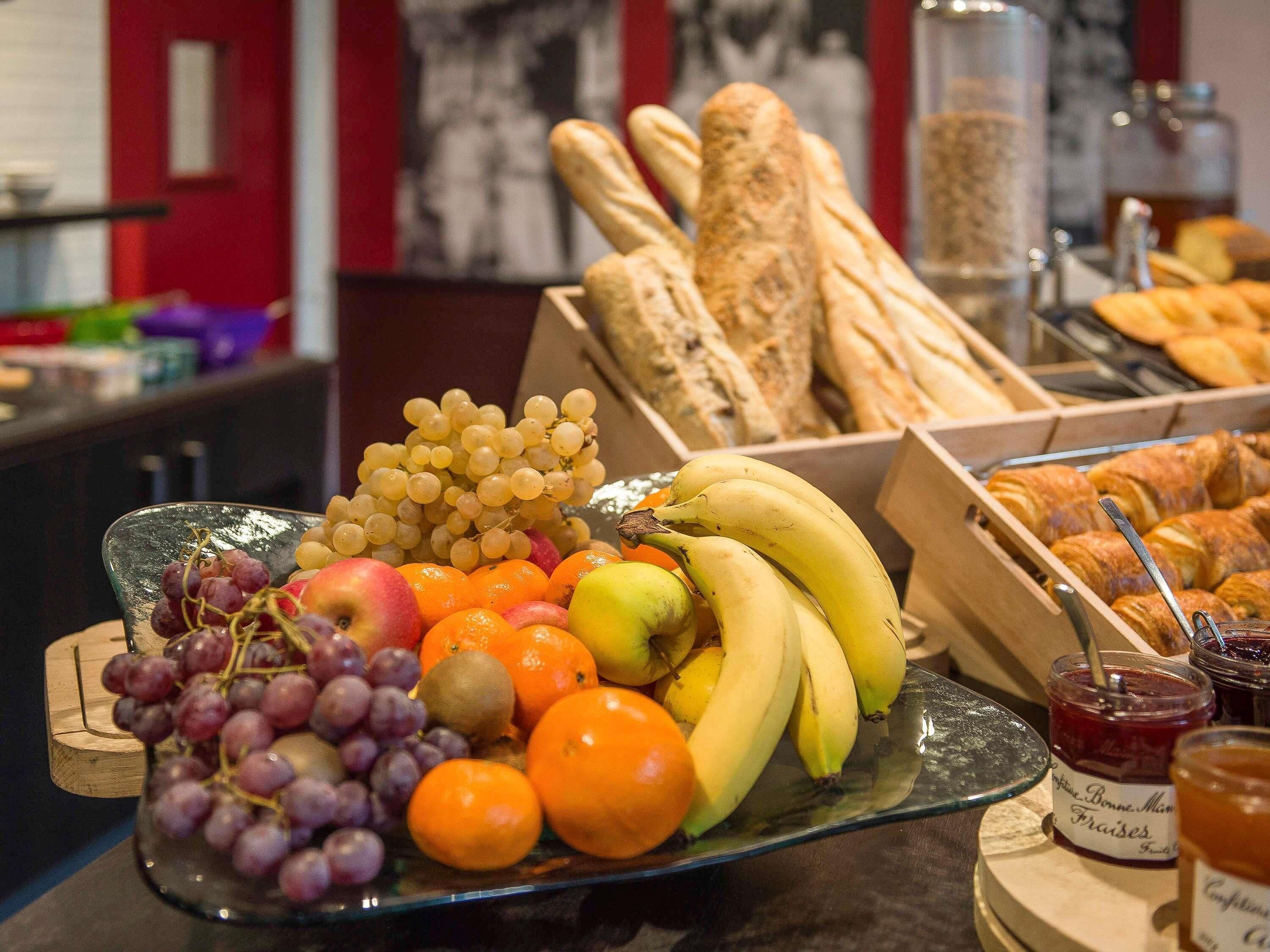 Un ricco buffet per la colazione con frutta, pane e marmellate.