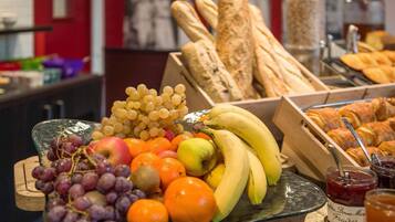 Un ricco buffet per la colazione con frutta, pane e marmellate.