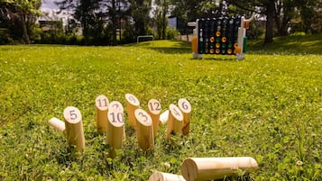 Ein grasbewachsenes Feld mit mit Nummern versehenen Holzbefestigungen, vermutlich für ein Spiel oder eine Aktivität.