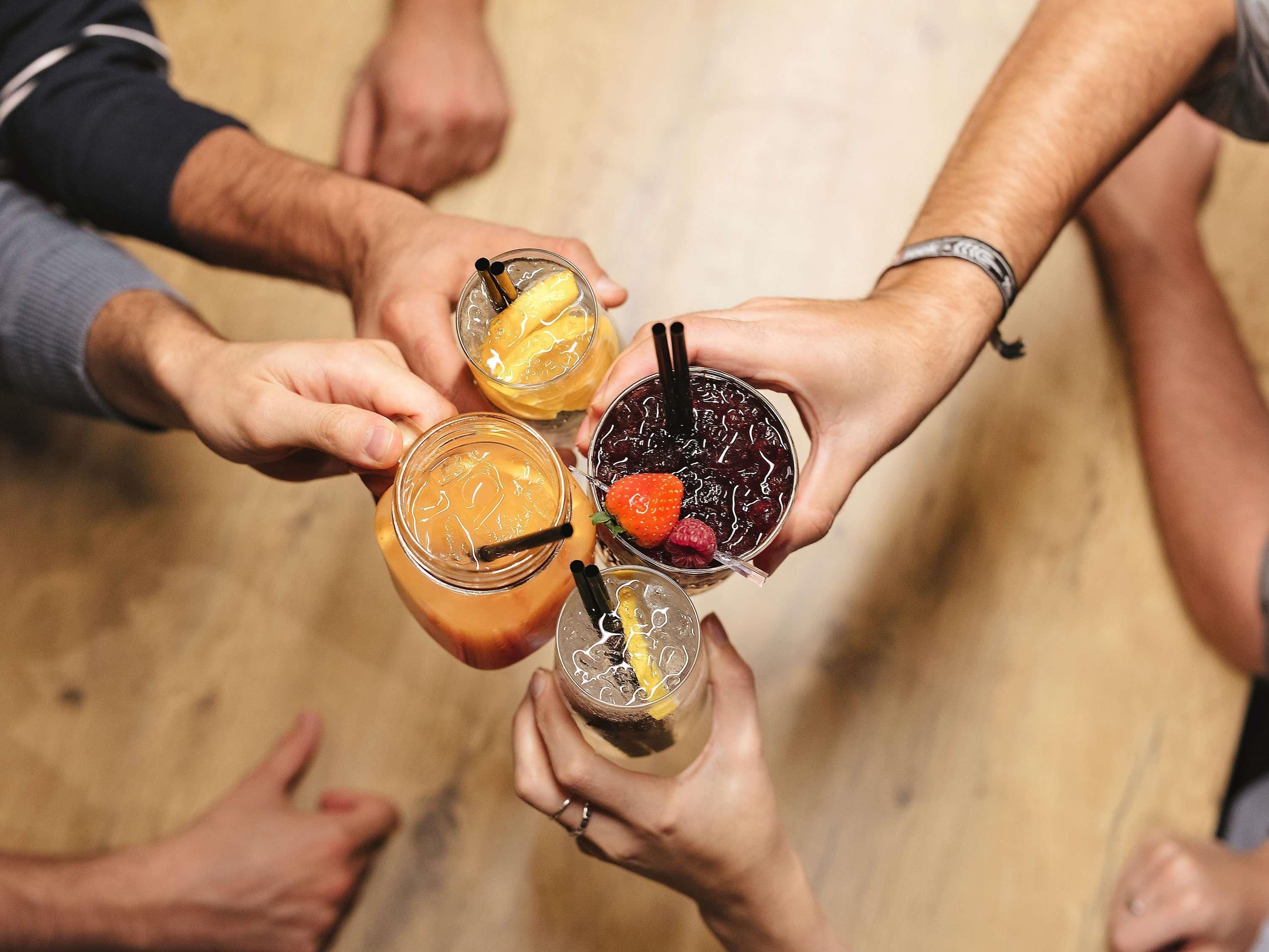 Un groupe de personnes tenant des verres contenant différentes boissons.