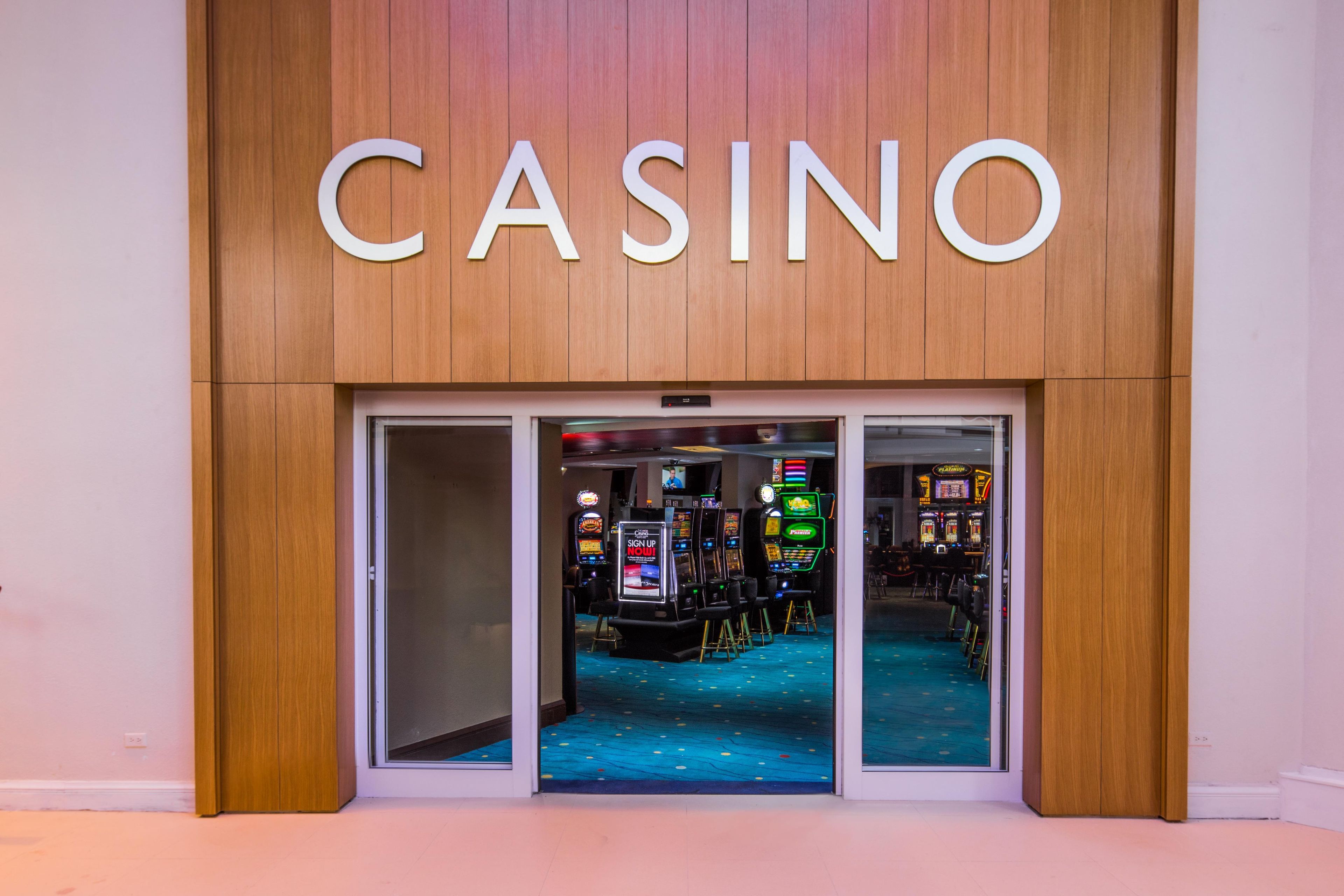 A casino entrance with a wooden facade and glass doors.