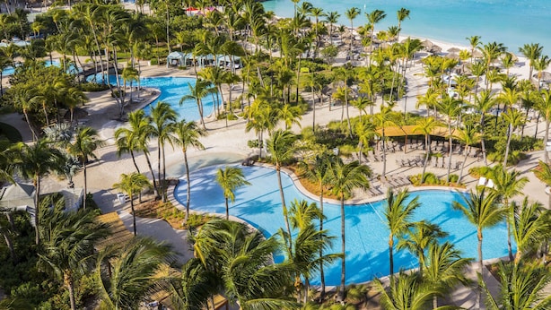 A resort with multiple swimming pools, palm trees, and a beach area. - Hilton Aruba Caribbean Resort and Casino (Noord)
