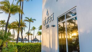 A spa building with a clear view of palm trees and a beach in the background. - Hilton Aruba Caribbean Resort and Casino (Noord)