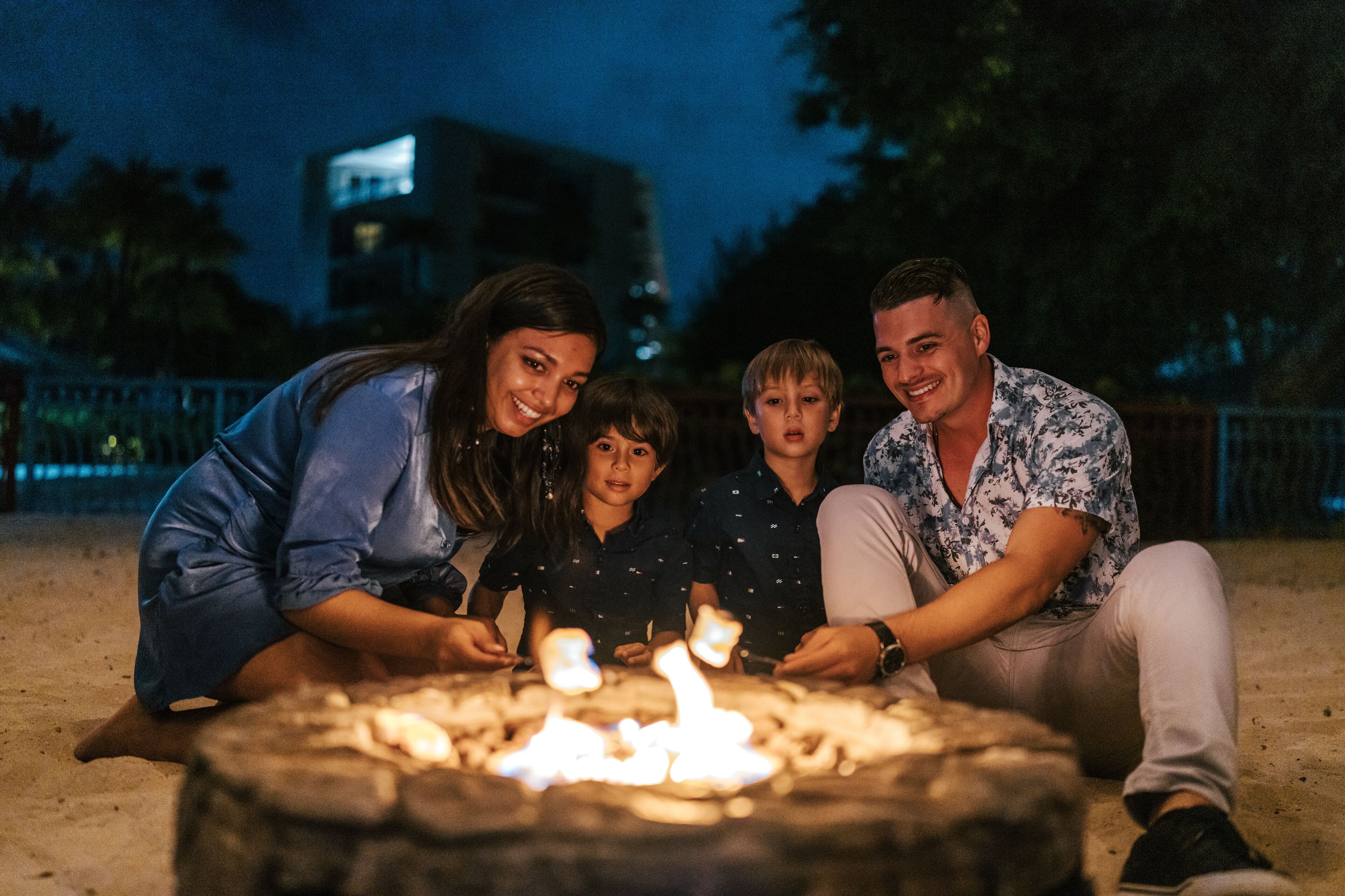 A family gathered around a campfire at night.