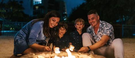 A family gathered around a campfire at night.