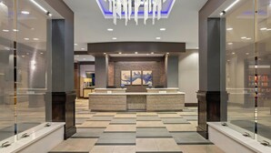 A modern reception area with a central desk, glass partitions, and a patterned floor. - Residence Inn by Marriott Daytona Beach Oceanfront (Daytona Beach Shores)