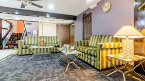 A living room with patterned sofas, a coffee table, and a lamp.
