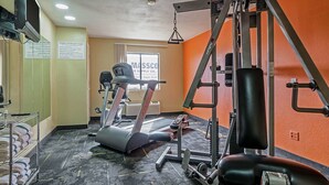 A gym with exercise equipment, a treadmill, and a weight machine.